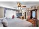 Bedroom featuring a ceiling fan, mounted TV and view of the bathroom at 11974 Rosetree S Pl, Seminole, FL 33772