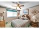 Cozy bedroom featuring a ceiling fan, quaint decor, and warm inviting tones at 11974 Rosetree S Pl, Seminole, FL 33772