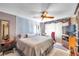 Relaxing bedroom features a ceiling fan, TV and comfortable furnishings at 11974 Rosetree S Pl, Seminole, FL 33772