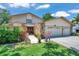Inviting two-story home with stone accents, manicured lawn, and a three-car garage at 11974 Rosetree S Pl, Seminole, FL 33772