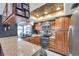 Well-lit kitchen with tiled backsplash, stainless steel appliances, wooden cabinets, and spacious countertops at 11974 Rosetree S Pl, Seminole, FL 33772