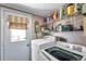 Functional laundry room with washer, dryer, shelving, natural light and convenient access to the outside at 11974 Rosetree S Pl, Seminole, FL 33772