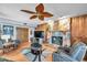 Cozy living room featuring a stone fireplace, leather furniture, and wood paneling at 11974 Rosetree S Pl, Seminole, FL 33772