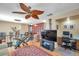 Spacious living room featuring a unique ceiling fan, TV, and home office at 11974 Rosetree S Pl, Seminole, FL 33772