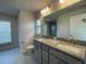 Bathroom with a double vanity, granite countertop, large mirror, and tile flooring and ample natural light at 13187 Ogden Glade Rd, Dade City, FL 33525