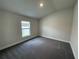 Cozy bedroom with gray carpet and a sunlit window overlooking the outdoors at 13187 Ogden Glade Rd, Dade City, FL 33525