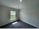 Cozy bedroom with gray carpet and a sunlit window overlooking the outdoors at 13187 Ogden Glade Rd, Dade City, FL 33525