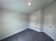 An empty bedroom with gray carpet and two white doors, offering a blank canvas at 13187 Ogden Glade Rd, Dade City, FL 33525