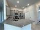 Well-equipped kitchen with granite countertops, stainless steel appliances, tile flooring, and gray cabinetry at 13187 Ogden Glade Rd, Dade City, FL 33525