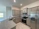 Modern kitchen featuring gray cabinets, granite countertops, stainless steel appliances and tile flooring at 13187 Ogden Glade Rd, Dade City, FL 33525