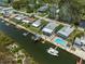 Aerial view of waterfront homes featuring a boat lift, pool, patio and dock at 14409 Birch St, Hudson, FL 34667