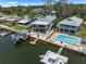 Aerial view of a waterfront property featuring a boat lift, pool, covered patio and dock at 14409 Birch St, Hudson, FL 34667