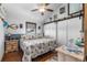 Bright bedroom with barn door closet, ceiling fan, and nautical themed quilt and furnishings at 14409 Birch St, Hudson, FL 34667