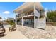Waterfront home featuring a covered patio with outdoor seating and access to the upper deck via exterior stairs at 14409 Birch St, Hudson, FL 34667