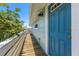 Inviting blue front door and wooden walkway leading to the side of the waterfront home at 14409 Birch St, Hudson, FL 34667