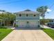 Two-story waterfront home with an attached two-car garage and meticulously manicured lawn at 14409 Birch St, Hudson, FL 34667
