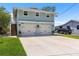 Two-story waterfront home with an attached two-car garage, concrete driveway, and lawn at 14409 Birch St, Hudson, FL 34667