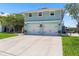 Two-story waterfront home with an attached two-car garage, and steps leading to the front entrance at 14409 Birch St, Hudson, FL 34667