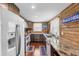 Rustic kitchen showcasing wood-paneled walls, granite counters, and stainless steel appliances at 14409 Birch St, Hudson, FL 34667