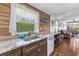 Kitchen showing a sink, granite counters, wood panels, and view to living area at 14409 Birch St, Hudson, FL 34667