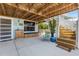 The outdoor patio offers a cozy seating area with a charming wooden cabinet and stairs to the upper deck, perfect for relaxing at 14409 Birch St, Hudson, FL 34667