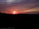 A vibrant sunset view over a treeline, highlighting the property's scenic location at 14409 Birch St, Hudson, FL 34667