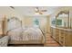 A serene main bedroom featuring wood floors, ceiling fan and a decorative dresser with matching mirror at 14564 110Th Ter, Largo, FL 33774