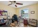Bright home office with ceiling fan, wood floors and large window views of backyard pool at 14564 110Th Ter, Largo, FL 33774
