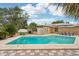 Backyard pool and patio with dining table and umbrellas, and solar panels on roof at 14564 110Th Ter, Largo, FL 33774