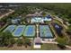 Aerial view of community tennis and pickleball courts, swimming pool, and surrounding landscape at 14610 Mondavi Ct, Tampa, FL 33626