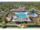 Elevated view of a community pool and clubhouse, accentuated by palm trees and meticulously maintained landscaping at 14610 Mondavi Ct, Tampa, FL 33626