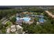 Beautiful aerial of community center with tennis courts, a basketball court, pool and fountain, all surrounded by trees at 14610 Mondavi Ct, Tampa, FL 33626