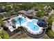 Aerial view of a community pool featuring a water slide and multiple pool areas, surrounded by trees and amenities at 14610 Mondavi Ct, Tampa, FL 33626