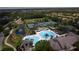 Aerial view of a community pool area, featuring a large pool with a fountain and surrounding tennis courts at 14610 Mondavi Ct, Tampa, FL 33626