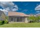 Home exterior showing a screened lanai and lush backyard with well-manicured landscaping at 14610 Mondavi Ct, Tampa, FL 33626