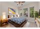Bright bedroom with a large bed, ceiling fan, bedside table, and windows overlooking the garden at 14610 Mondavi Ct, Tampa, FL 33626