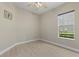 Neutral bedroom with ceiling fan and view of greenery through the window at 14610 Mondavi Ct, Tampa, FL 33626
