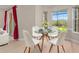 Charming breakfast nook features a glass table, white chairs and sunlit windows overlooking the backyard at 14610 Mondavi Ct, Tampa, FL 33626