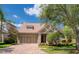 Beautiful single-Gathering home featuring a well-maintained lawn, brick driveway, and a two-car garage at 14610 Mondavi Ct, Tampa, FL 33626