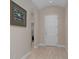 Hallway with art, neutral walls, and a white front door at 14610 Mondavi Ct, Tampa, FL 33626