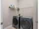 A tidy laundry room features a washer, dryer, and wire shelving for storage at 14610 Mondavi Ct, Tampa, FL 33626