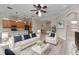 Bright living room with white sofas, modern decor, and a view of the open kitchen at 14610 Mondavi Ct, Tampa, FL 33626