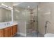 Bright bathroom featuring a glass-walled shower, a stone floor, and wood vanity at 14610 Mondavi Ct, Tampa, FL 33626