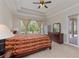 Bright main bedroom featuring a ceiling fan, tray ceiling, and an exterior entrance to the lanai at 14610 Mondavi Ct, Tampa, FL 33626