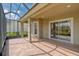 Screened patio features brick flooring and a sliding glass door leading to the backyard at 14610 Mondavi Ct, Tampa, FL 33626