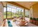 Comfortable screened patio area features seating with blue pillows and a view of the landscaped backyard at 14610 Mondavi Ct, Tampa, FL 33626