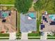 Aerial view of a single-Gathering house featuring a backyard pool, well-kept landscaping, and neighborhood setting at 1521 Brittany Ct, New Port Richey, FL 34655