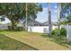 Backyard featuring lush green grass, white fencing, and mature trees for added privacy at 1521 Brittany Ct, New Port Richey, FL 34655