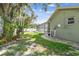Backyard showing a well-kept lawn, a paved walkway, and landscaping near the house at 1521 Brittany Ct, New Port Richey, FL 34655