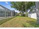 Expansive backyard with well-maintained lawn, privacy fence, and screened-in pool area at 1521 Brittany Ct, New Port Richey, FL 34655